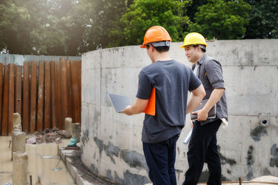 Architects walking by wall at site