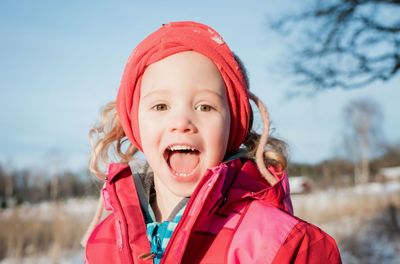 Portrait of young girl laughing whilst playing outside in winter