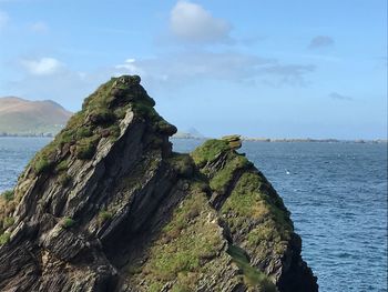 Scenic view of sea by cliff against sky