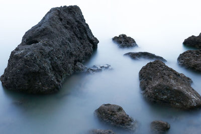 Rocks in sea against sky