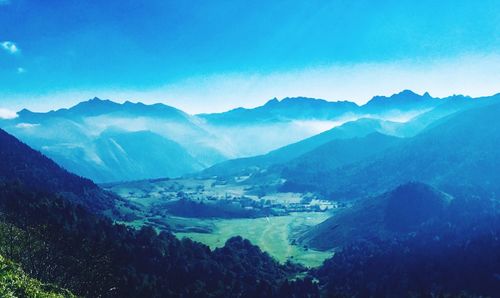 Scenic view of mountains against blue sky