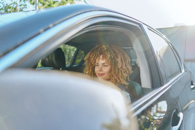 Rear view of young woman sitting in car