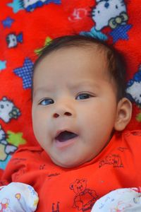 Portrait of cute baby boy yawning while lying on bed