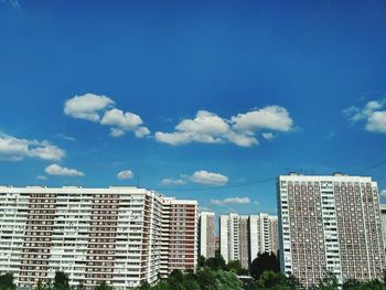 Low angle view of skyscrapers against blue sky