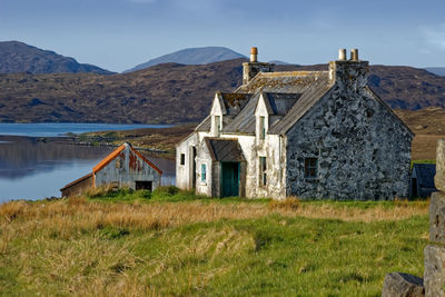 Old house on field against sky