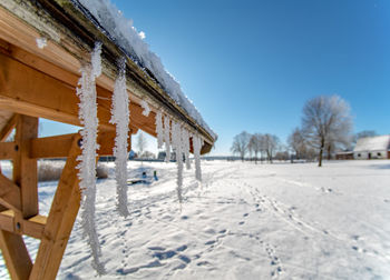 House on snow covered field against sky