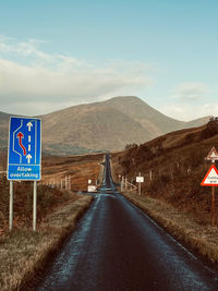 Road by mountain against sky