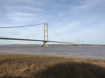 View of suspension bridge against cloudy sky