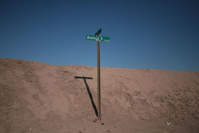 Information sign on field against clear sky