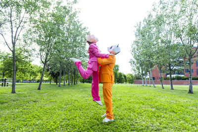 Full length of woman with arms raised in park