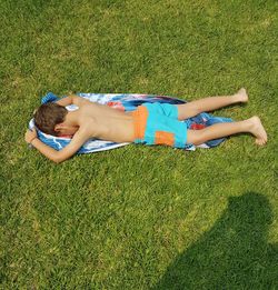 High angle view of girl lying on grassy field