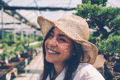 Close-up of smiling young woman in greenhouse