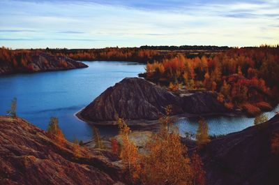 Scenic view of rocks by lake against sky