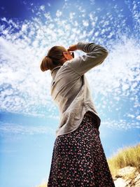 Rear view of woman standing against sky