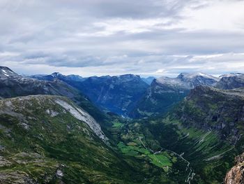 Scenic view of valley and mountains against sky