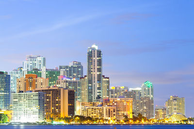 Illuminated buildings in city against sky