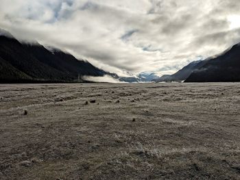 Scenic view of land and mountains against sky