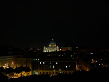 Illuminated cityscape against sky at night