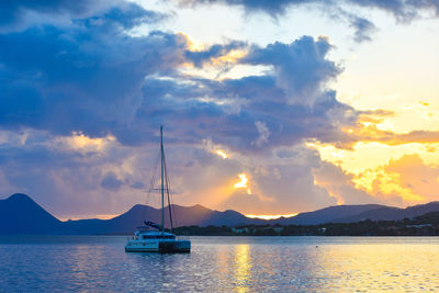 Sailboats in sea against sky during sunset