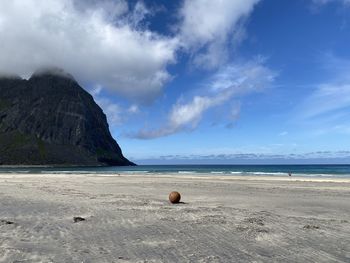 Scenic view of orb on a beach against mountain and sky