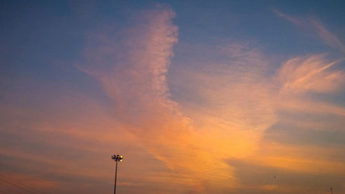 Low angle view of silhouette street light against dramatic sky