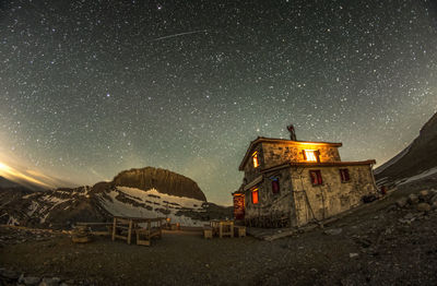 Panoramic view of illuminated building against sky at night