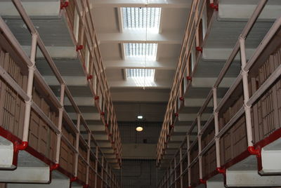 Low angle view of illuminated lights hanging on ceiling in building