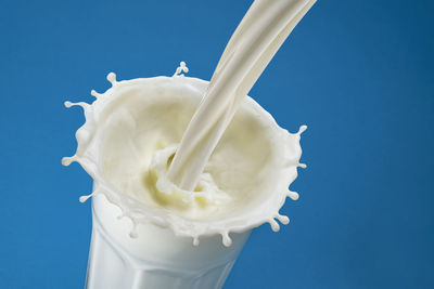 Close-up of white ice cream against blue sky