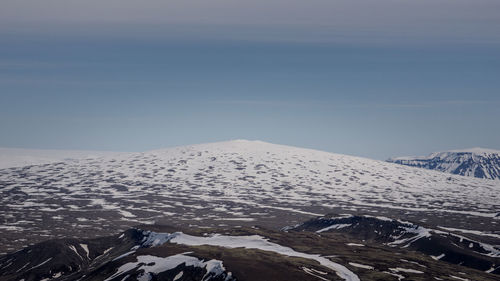 Aerial view of snowcapped mountain against sky