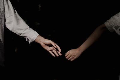 Couple reaching hands at night