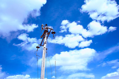 Low angle view of windmill against blue sky