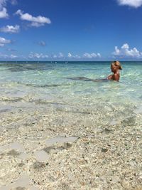 Shirtless man in sea against sky