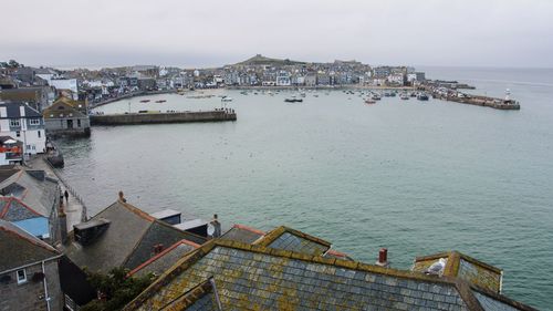 High angle view of townscape by sea against sky