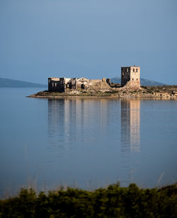 Built structure by sea against clear sky