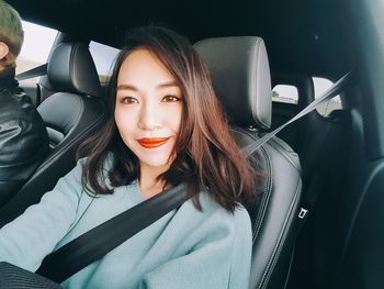 Portrait of young woman sitting in car