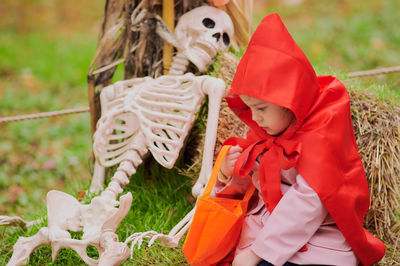 Young gril in a red riding hood costume on halloween
