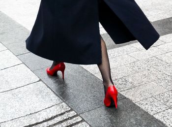 Low section of woman walking on sidewalk