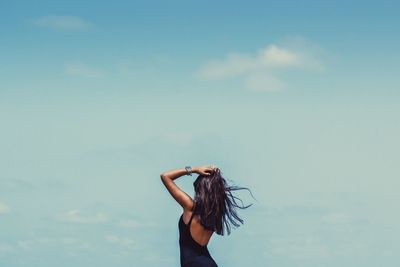 Young woman standing against clear sky