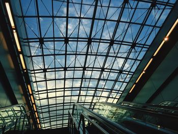 Low angle view of escalators against skylight