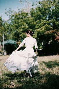 Rear view of bride walking at park