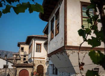 Low angle view of buildings and trees against sky