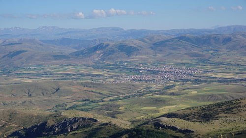 Aerial view of agricultural field and mountains against sky