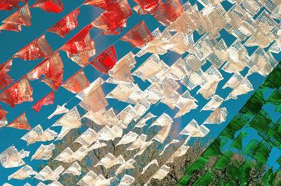 Low angle view of colorful flags hanging against clear blue sky