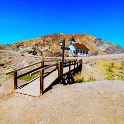 Built structure on landscape against clear blue sky