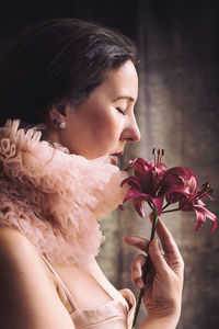 Side view of woman blowing flowers