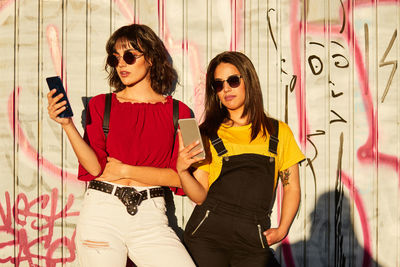 Portrait of friends standing on wall