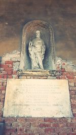 Statue of buddha against wall