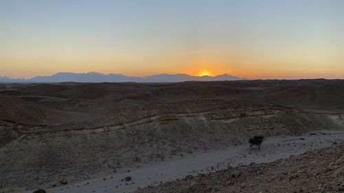 Scenic view of desert against sky during sunset