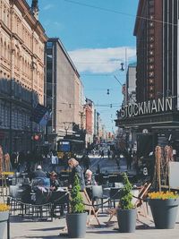 People on street in city against sky