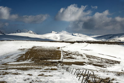 Scenic view of snow covered mountains against sky